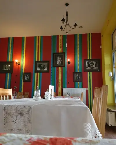 Kolorowa ściana w pasy i stoliki przy oknie